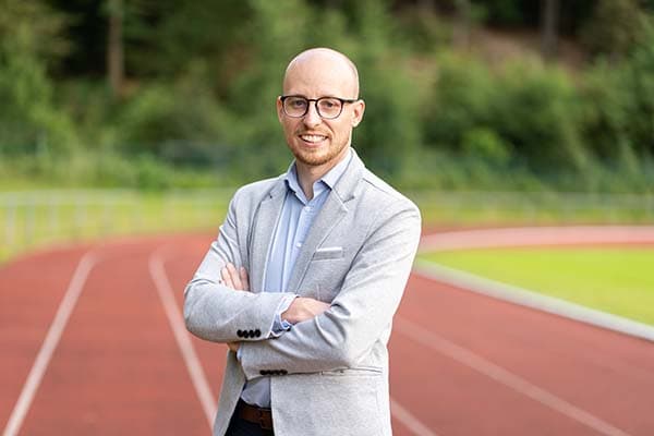 Alexander Beuerle mit einer Tartanbahn im Hintergrund